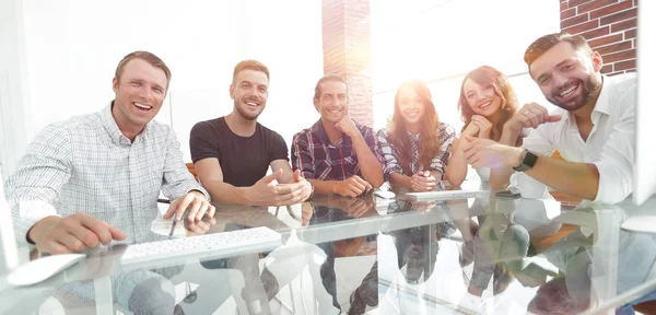 Jovem equipe de negócios sentado na mesa — Fotografia de Stock