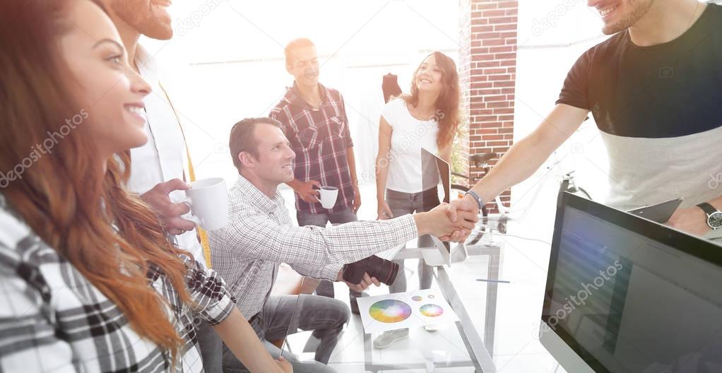 handshake of colleagues in a creative office.