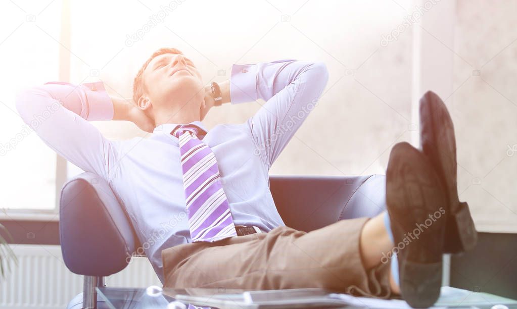 Young businessman leaning back in his chair