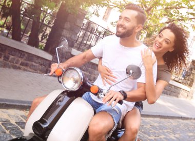 Şık genç çift bir scooter sokakta oturuyor..