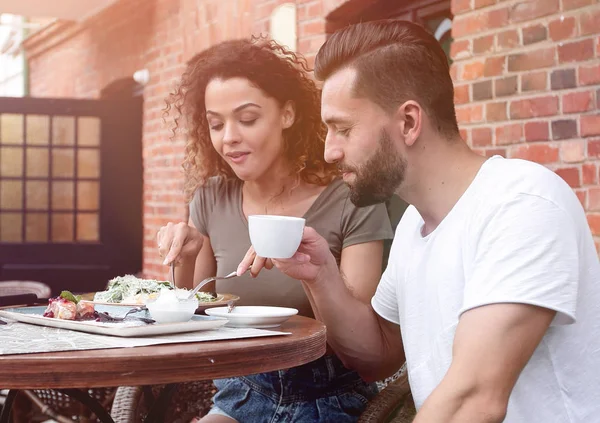 Porträt eines schönen romantischen Paares, das in einem Café mit Kaffee sitzt — Stockfoto