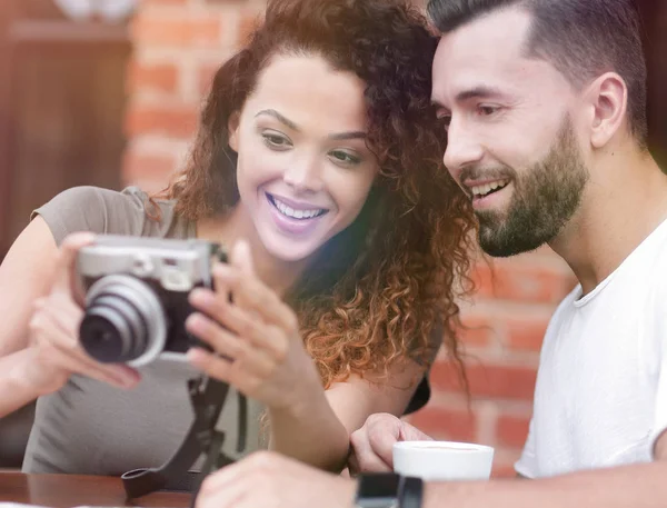 Retrato de um casal sentado em um café e olhando fotos — Fotografia de Stock