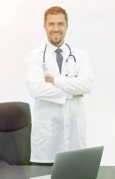 Retrato do médico de pé perto da área de trabalho — Fotografia de Stock