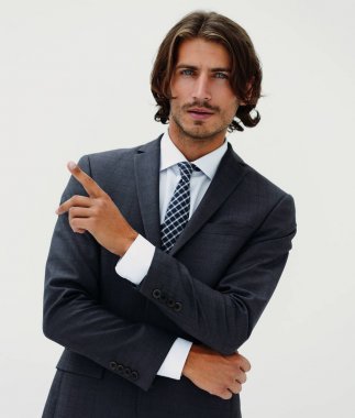 Genç ve yakışıklı bir işadamı parmağıyla işaret ediyor.