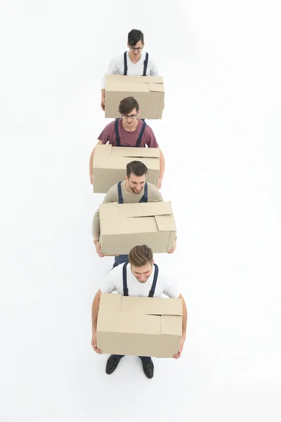 Mladí stěhovací společnosti drží boxy, stojící v řadě, izolované na bílém — Stock fotografie