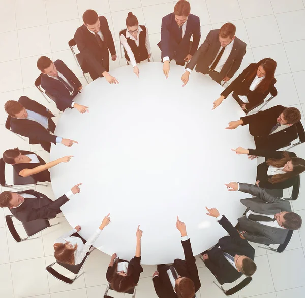 Equipo de negocios indica el centro de la mesa redonda . —  Fotos de Stock