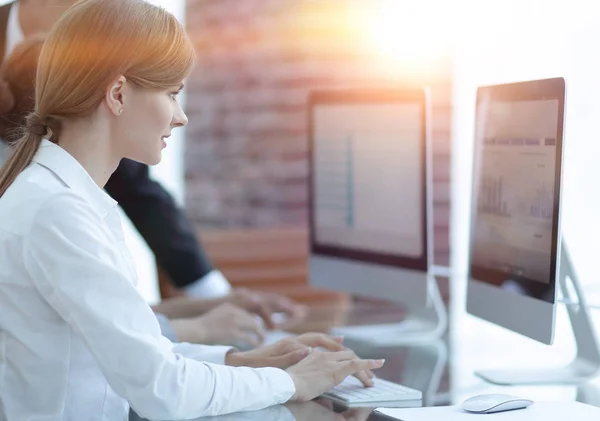 Werknemers die werken op personal computers met financiële gegevens — Stockfoto