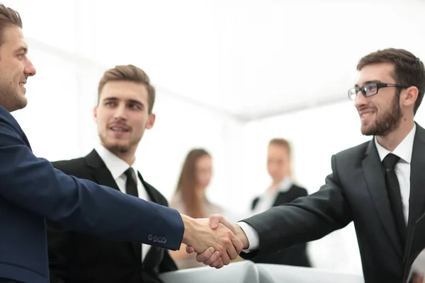 Partner che concludono un accordo e stringono la mano alla presenza dei membri del team — Foto Stock