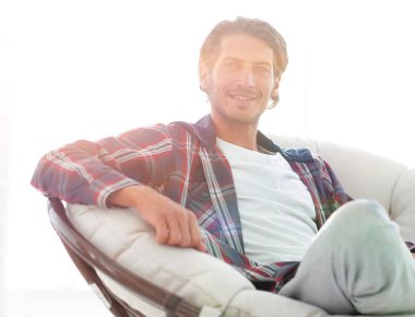 gülümseyen bir adam büyük bir koltukta otururken köpeğini okşayarak Close-Up.