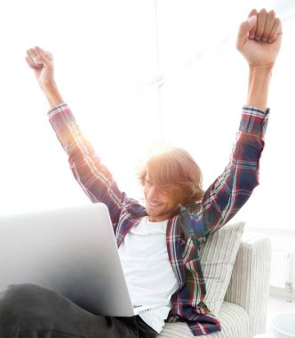 çok mutlu genç adam evde laptop ile çalışma.