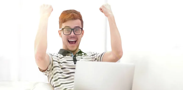 Homem feliz com laptop sentado no sofá — Fotografia de Stock