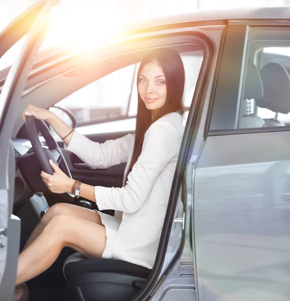 Moderne Geschäftsfrau sitzt hinter dem Steuer eines Autos, auf dem Parkplatz — Stockfoto