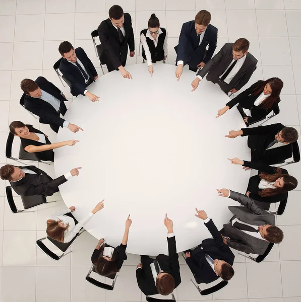 Business team indicates the center of the round table. — Stock Photo, Image