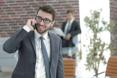 ofisinde smartphone cep telefonu ile konuşurken işadamı