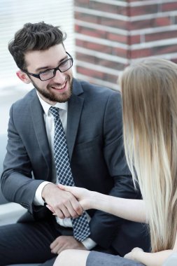 Yöneticisi ve müşteri ofis lobisinde otururken el sıkışma.