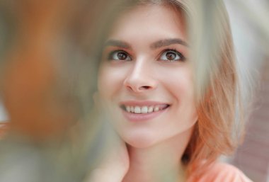 kadın yüzü bulanık arka plan üzerinde gülümseyen portresi.