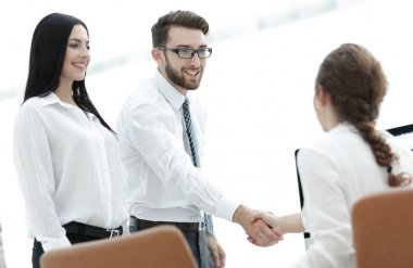 bir meslektaşım ile el sıkışan genç iş kadını