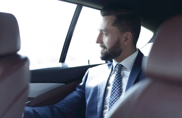Usmívající se obchodní muž sedí na zadním sedadle auta — Stock fotografie