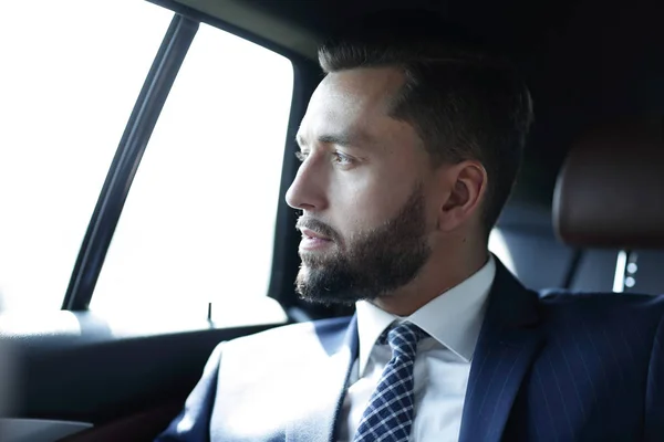 Geschäftsmann sitzt auf dem Rücksitz eines Autos — Stockfoto
