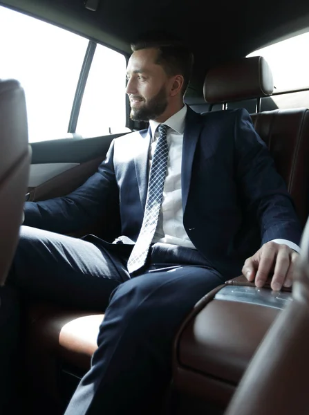 Podnikatel, sedí na zadním sedadle auta — Stock fotografie