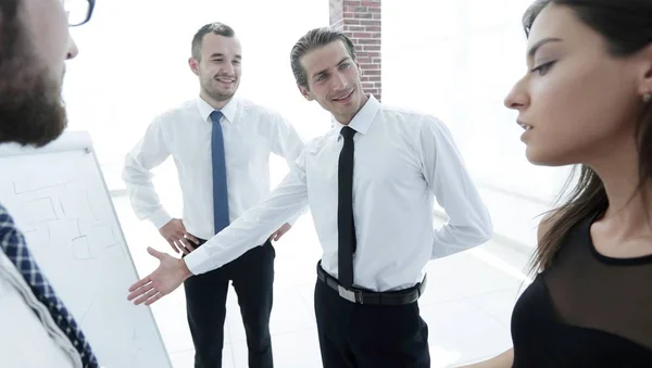 Gerente sênior de apontar equipe de negócios em um flipchart em branco . — Fotografia de Stock