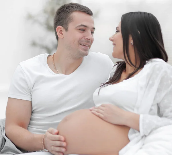 Manžel a těhotnou ženu sedící mluví na gauči. — Stock fotografie