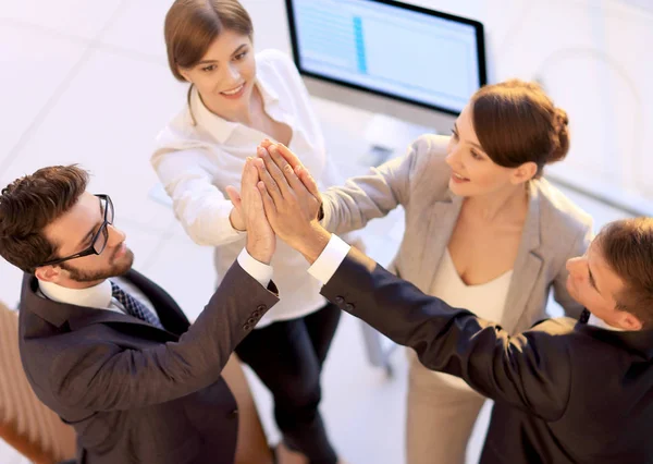 Equipe de negócios bem sucedida dando uns aos outros um high-five, de pé no escritório — Fotografia de Stock
