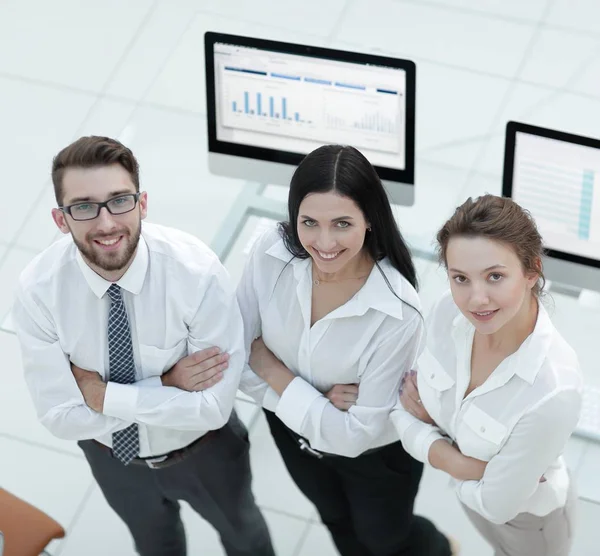 Equipe de negócios de sucesso em pé perto do local de trabalho — Fotografia de Stock