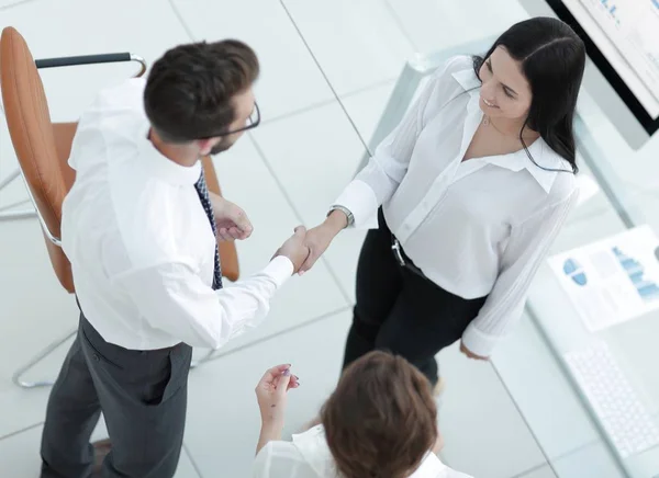 handshake manager and employee near the workplace