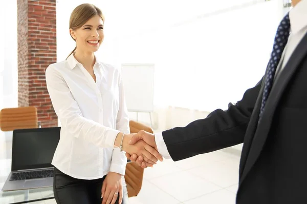 Mulher gerente recebe o cliente com um aperto de mão . — Fotografia de Stock
