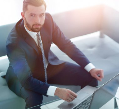 mali grafikler ile bir dizüstü bilgisayar üzerinde çalışan iş adamı