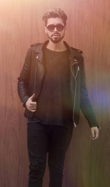 Siyah deri ceketli ve kot pantolonlu bir adam