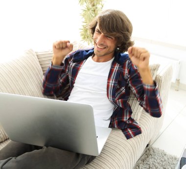 çok mutlu genç adam evde laptop ile çalışma.