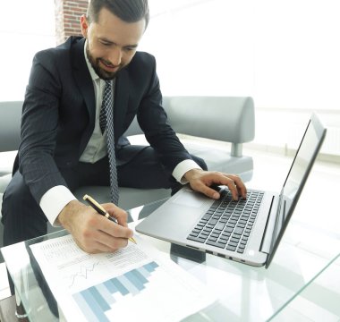 Dizüstü bilgisayarda çalışan ve Notlar not defterinde yapma şık adam