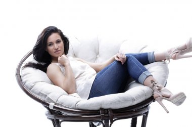 Yuvarlak, yumuşak bir sandalyede dinlenen modern genç kadın..