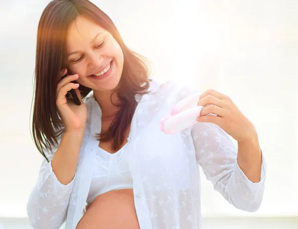 Gülümseyen hamile kadın onun smartphone üzerinde söz. — Stok fotoğraf