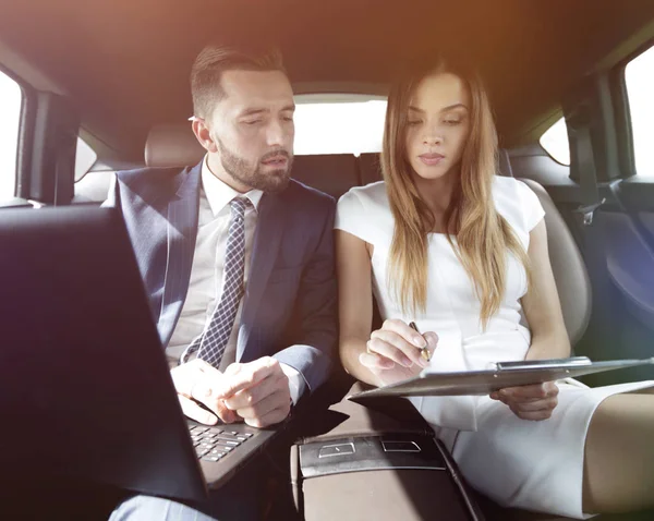 Man and woman discussing work documents in taxi — Stock Photo, Image