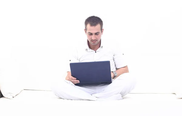 Człowiek pracuje na laptopie, siedząc na kanapie — Zdjęcie stockowe