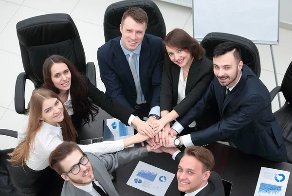 Equipo de negocios con las manos juntas en el escritorio —  Fotos de Stock