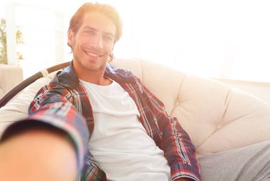 bir sandalyede oturuyor ve elini tutarak kendine güvenen adam.