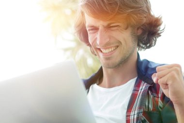 bir sehpa oturan bir dizüstü bilgisayar ile çok mutlu adam.