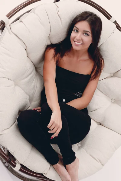 Sonriente joven mujer descansando en gran sillón suave — Foto de Stock