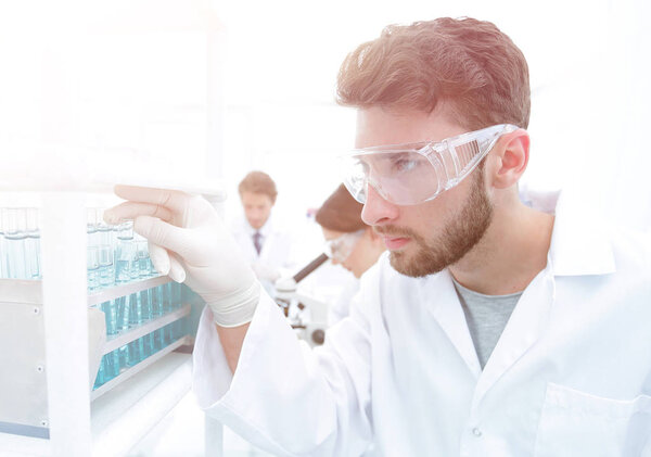 A young man doing an experiment in a chemical laboratory