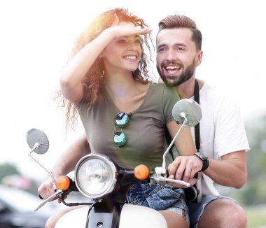 Güzel genç bir çift bir scooter sürme sırasında gülümsüyor