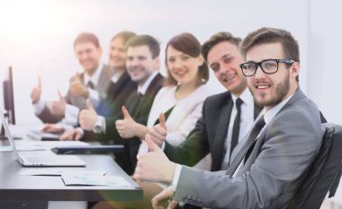 iş takım masasında otururken başparmak yukarıya ile