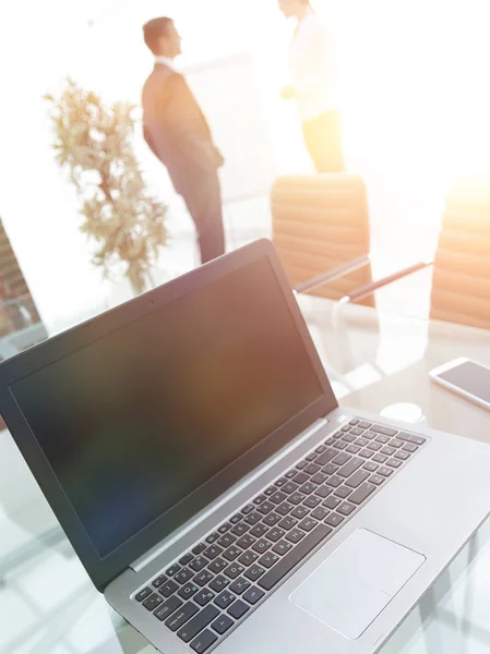 Laptop and a smartphone on the desktop in the conference room. — Stock Photo, Image