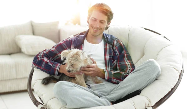 Bel ragazzo con un cane seduto in una grande poltrona . — Foto Stock