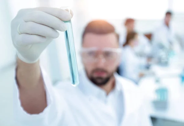 Imagem está turva. jovem cientista segurando tubo com os reagentes — Fotografia de Stock