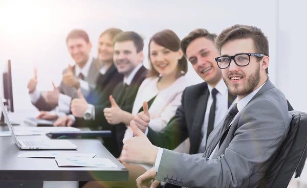 Business team met duimen omhoog zittend op zijn Bureau — Stockfoto