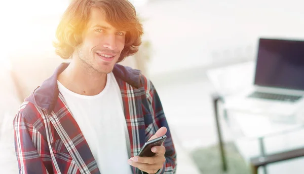 modern guy with a smartphone on a blurry background.